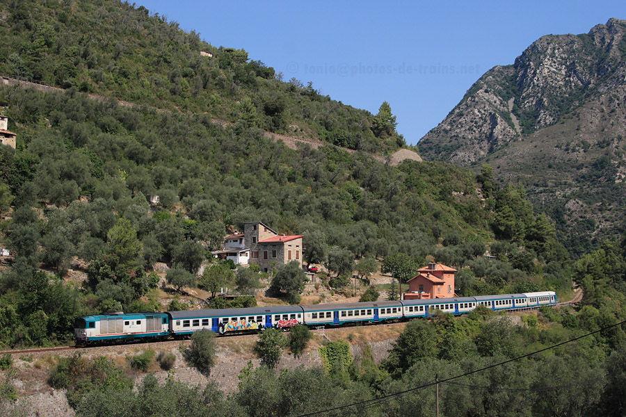 Parti depuis quelques minutes de la gare de Breil, le train Regionale 22977 Cuneo - Taggia d&eacute;vale les pentes de la vall&eacute;e de la Roya. On aper&ccedil;oit en haut la ligne allant vers Nice.