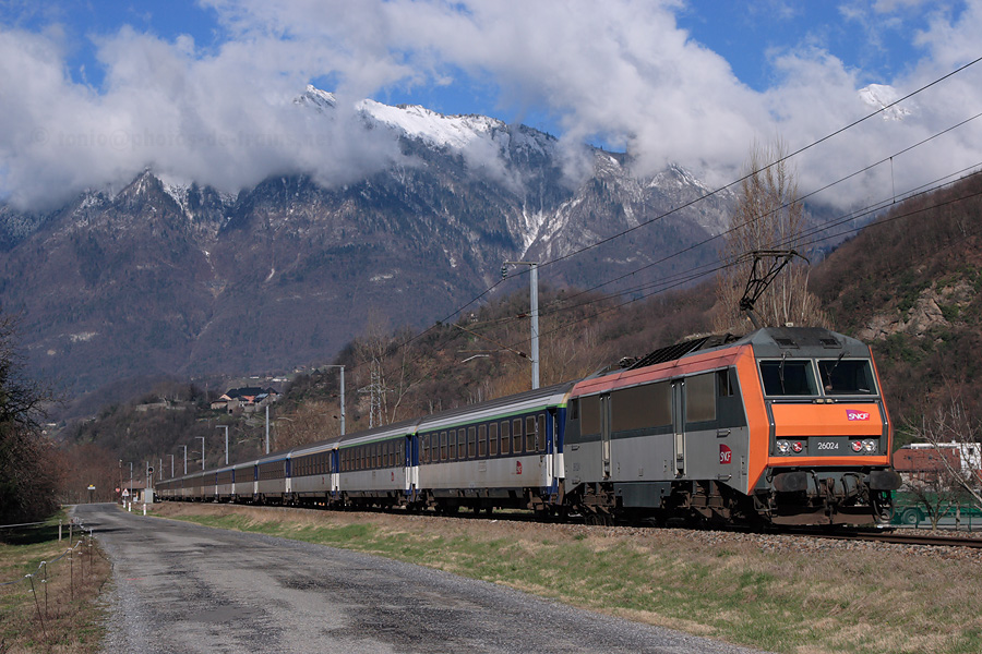 Vue du Corail Lunéa 4450 "Rhone-Océan" Quimper - Bourg-Saint-Maurice, quelques minutes après son départ de la gare d'Albertville et tracté par la BB 26024.
