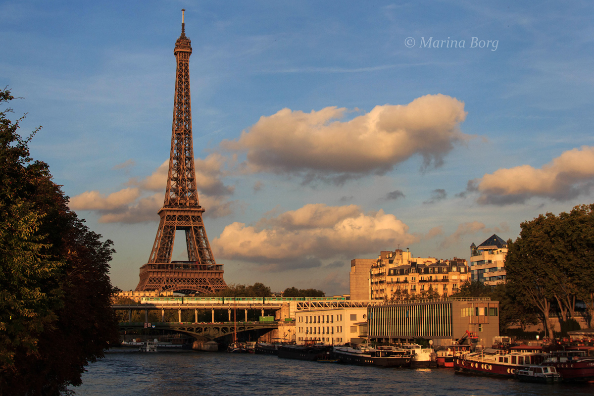 Un métro de la ligne 6 franchit le pont de Bir-Hakeim sur la Seine dans un décor typiquement parisien, sur fond de tour Eiffel.