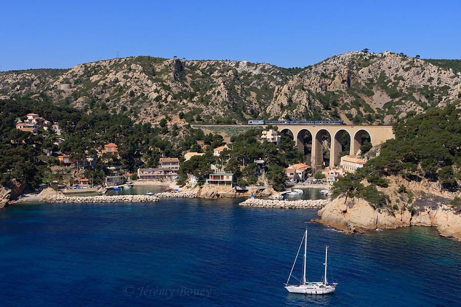 C'est dans ce splendide panorama méditerranéen sur le port de Méjean que passe ce TER Marseille-St-Charles - Miramas, assuré par le BB 67560 En Voyage et la RIO 195.