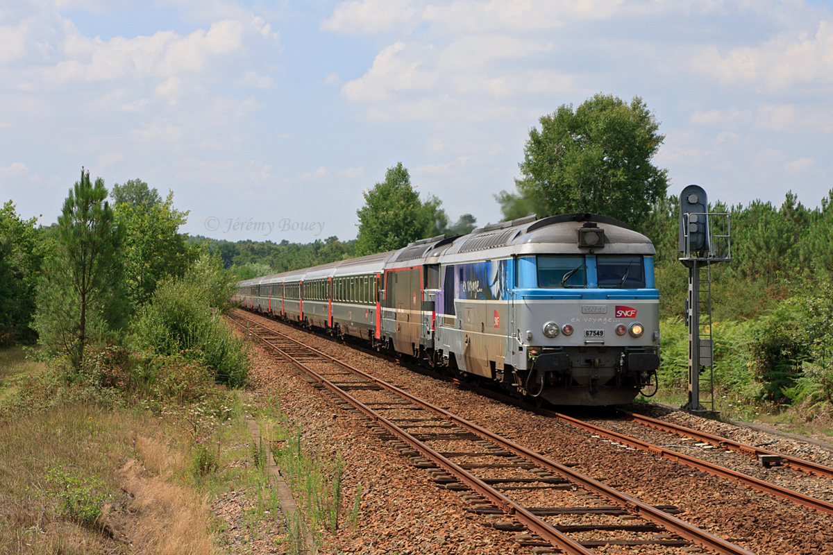 Alors qu'il quitte St-Mariens-St-Yzan, ce train de pèlerins à destination de La Roche-sur-Yon est vu à la frontière entre les régions Aquitaine et Poitou-Charentes. En tête, le BB 67549 ex-Marseillais, suivi du BB 67445.