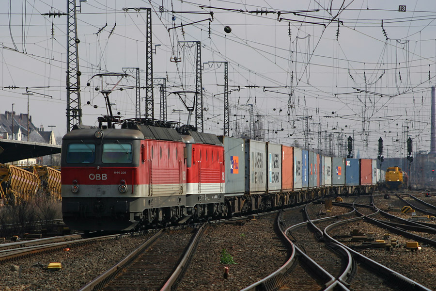 Une UM de BR 1144 autrichiennes, 1144 229 en t&ecirc;te, passe &agrave; F&uuml;rth, pr&egrave;s de Nurnberg avec un complet de containers. Leur pr&eacute;sence para&icirc;t assez inhabituel aussi profond en Allemagne. A c&ocirc;t&eacute;, une machine de manoeuvre d'un priv&eacute; attend pour aller au remplissage de gazoil.