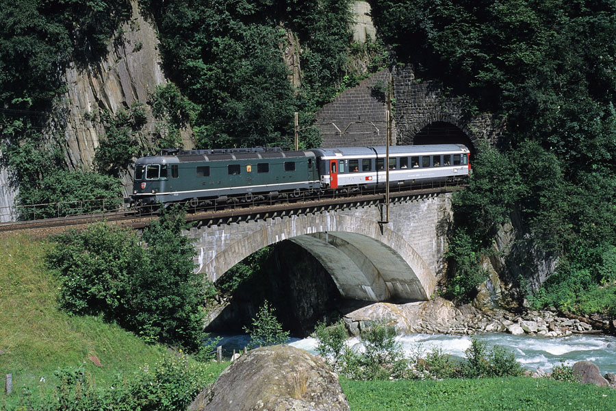 Tract&eacute; par la Re 6/6 11628 (armoiries de Konolfingen), le train IC 252 Ticino, reliant Milano Centrale &agrave; Basel SBB, sort du dernier tunnel h&eacute;lico&iuml;dal de Wassen.