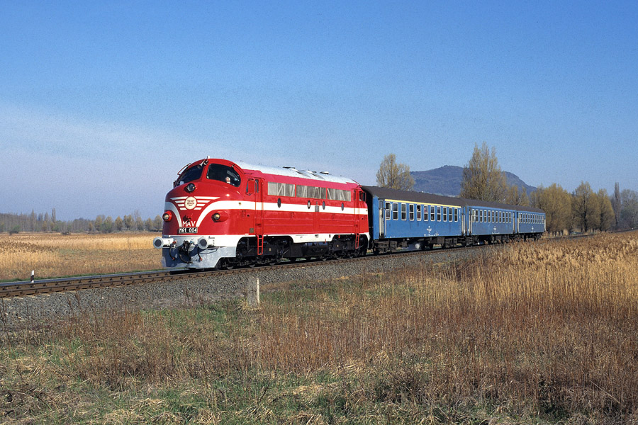 Tract&eacute; par la locomotive M61 004 (remise en livr&eacute;e d'origine &agrave; l'exception de l'&eacute;toile sur la face frontale), le train r&eacute;gional 13977 Tapolca - Csajag va arriver en gare de Badacsonyt&ouml;rdemic.