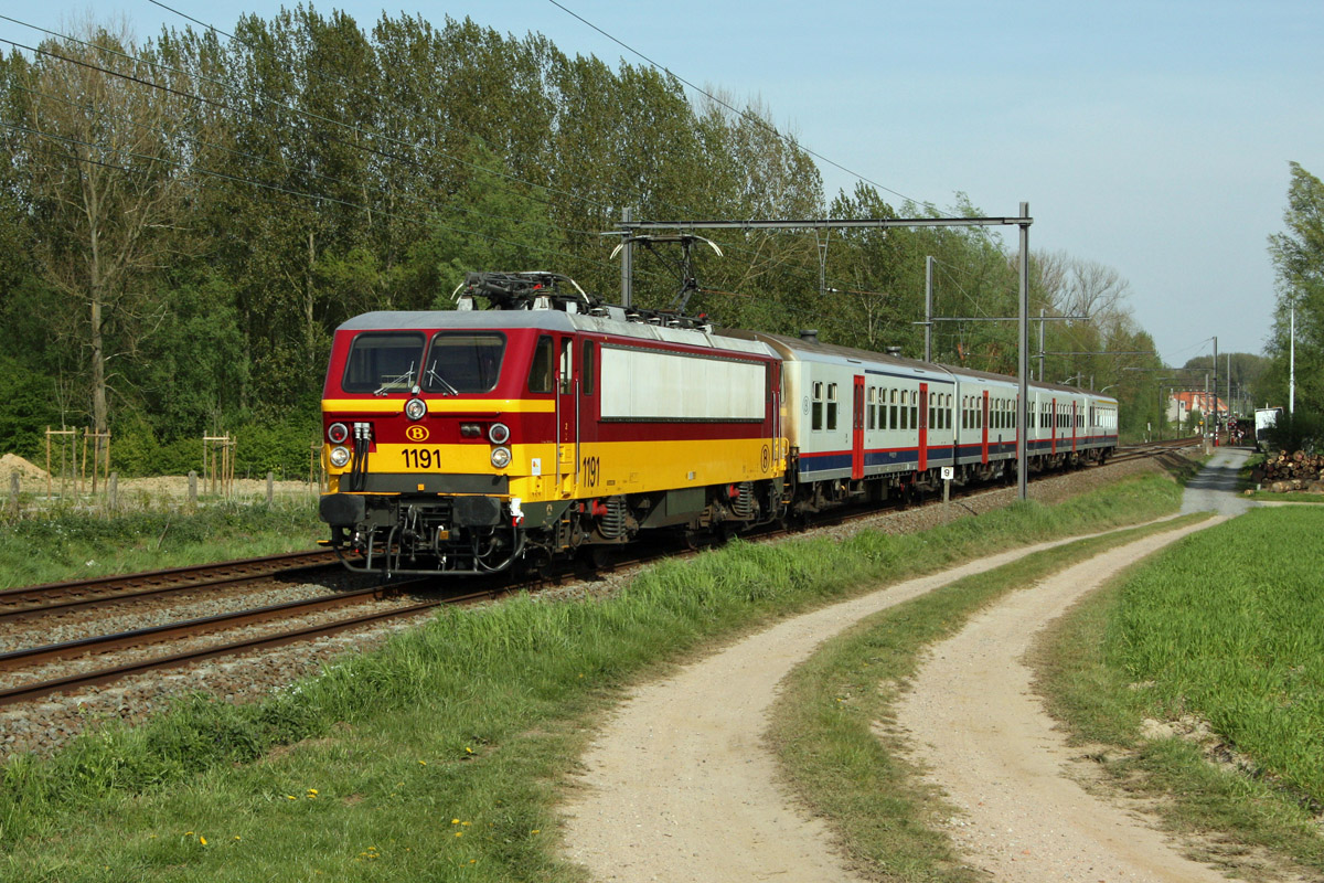 Tracté par la locomotive 1191, le train P 8969 Bruxelles Midi - Jette - Ternat - Zottegem vient de quitter la halte de Welle. Depuis fin 2009, les locomotives de la série 11 (numérotées 1181 à 1192) ont été complètement retirées du service Benelux entre Bruxelles et Amsterdam. En compensation, elles assurent dorénavant la traction d'un certain nombre de trains d'heure de pointe.