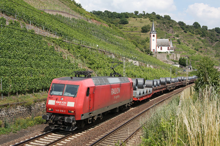 Tract&eacute; par la 145 016-2, un train de fret (transport de rouleaux de t&ocirc;le) vient de passer &agrave; hauteur de la St. Johanniskirche dans le village de Hatzenport.