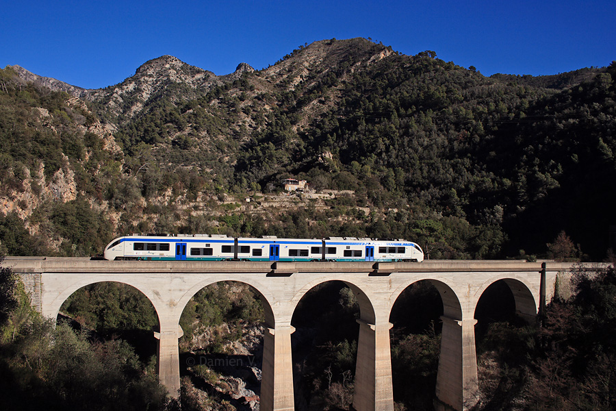 L'ALn 501/502 054 franchit la Roya sur le viaduc d'Olivetta, peu après avoir desservi la gare du même nom. Il assure le train régional 22975 Torino-Porta-Nuova - Taggia-Arma.
