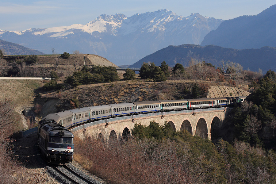 Passage sur le Viaduc du Bramafan, pr&egrave;s d'Embrun, d'une rame mixte de 10 voitures Corail et USI, emmen&eacute;es par deux di&eacute;sels bleus. Ils assurent le train 17352 Brian&ccedil;on - Lyon-Part-Dieu.