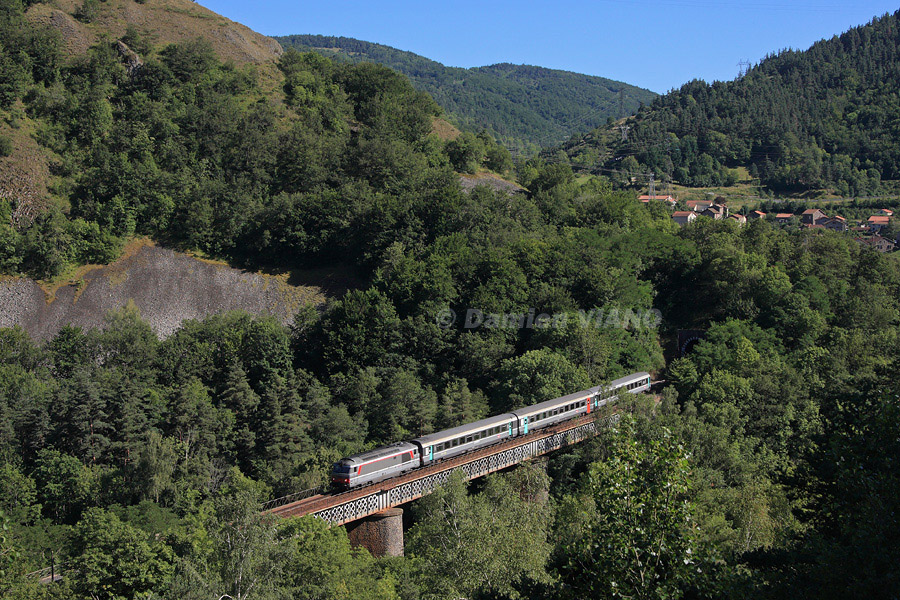 La BB 67547 et ses trois voitures composant le C&eacute;venol Al&egrave;s - Clermont-Ferrand du jour se faufilent dans la for&ecirc;t, peu apr&egrave;s Monistrol-d'Allier.
