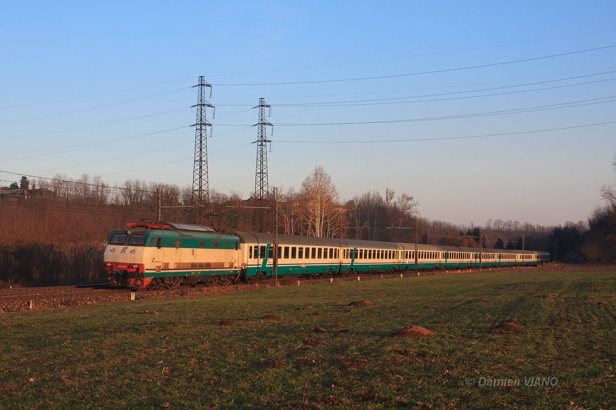 L'EC 22 Milano - Zürich, assuré par la locomotive E 444-091 et une rame Trenitalia, passe sous les derniers rayons du soleil du côté de Carimate, entre Milan et la frontière suisse.