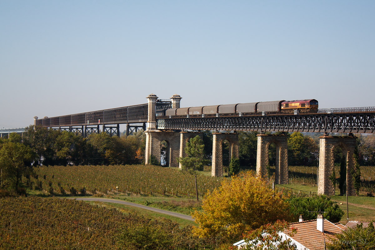La Class 66223, en charge d'un train Bordeaux-Hourcade - La Mothe-Achard, franchit la Dordogne par l'imposant viaduc.