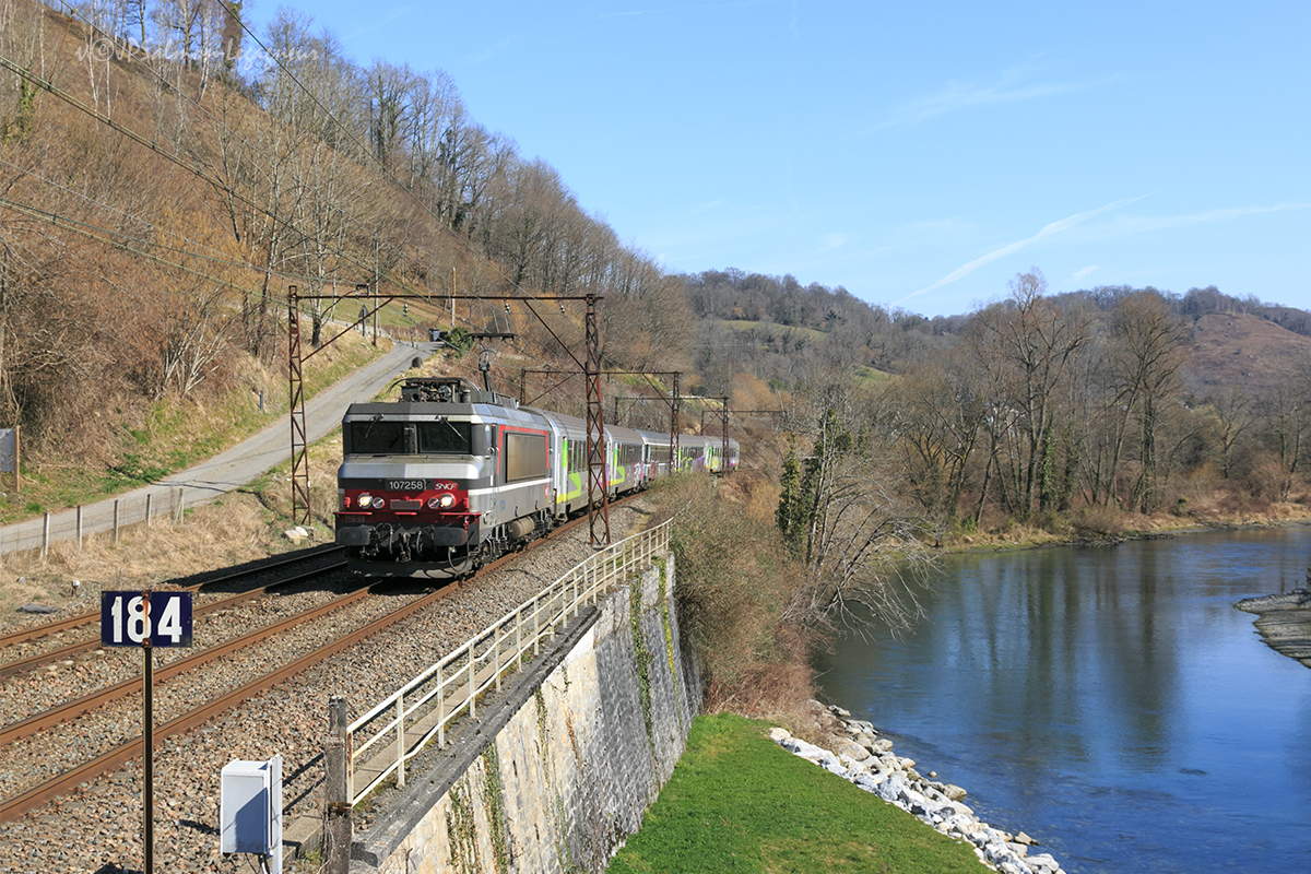 La BB 7258 remorquant un Intercité Toulouse - Bayonne, est vue peu après son départ de Lourdes, au bord du Gave de Pau.