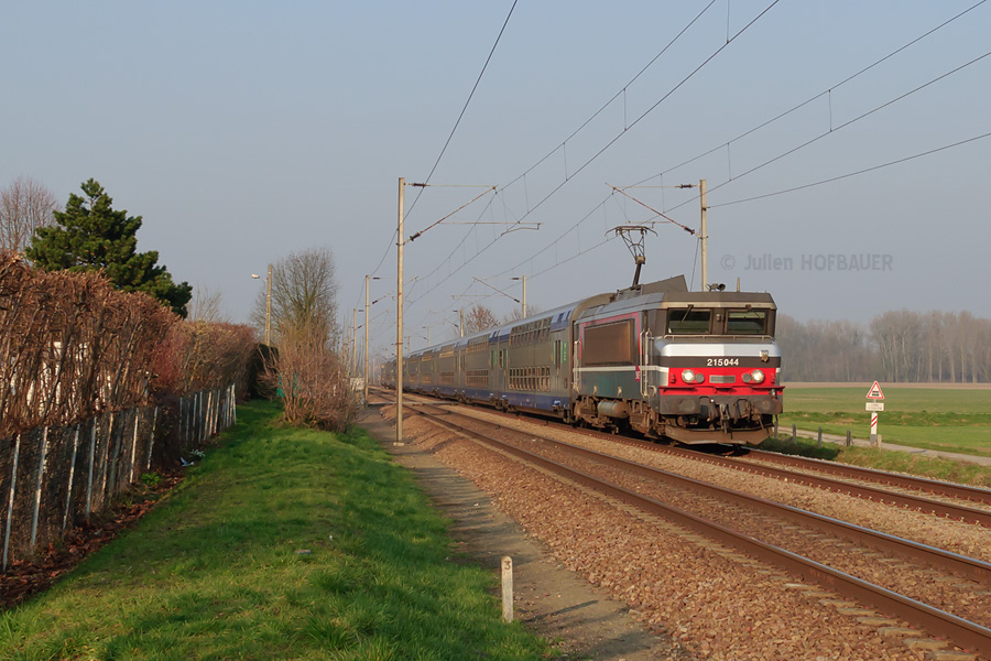 La BB 15044, surprise par un début de soirée ensoleillée à Armancourt, emmène sa rame de V2N picarde vers Paris-Nord.