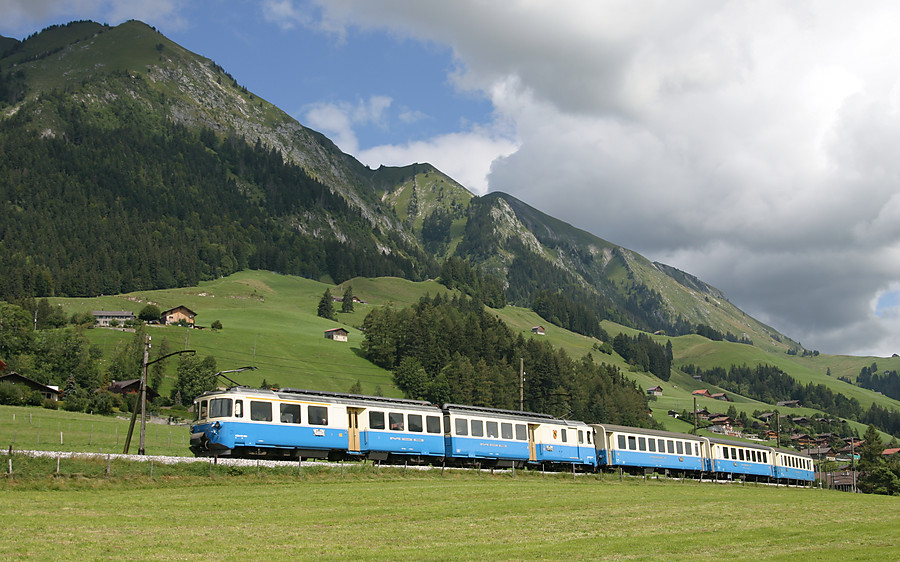 Une 4000 du MOB et sa rame bleu et cr&egrave;me passe dans les pr&eacute;s de Ch&acirc;teau d'Oex, sous la chaine des Vanils.