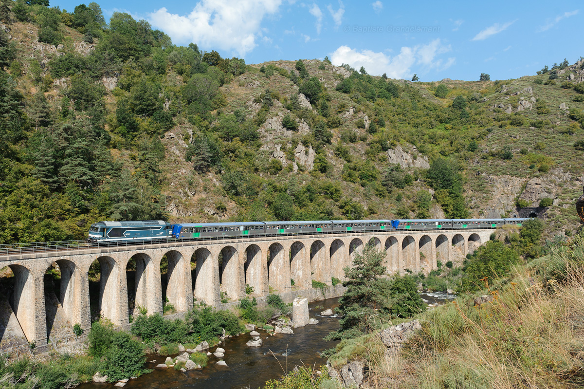 Composé des RRR 24 et 26 et tracté par la BB 67601, le train touristique faisant découvrir les superbes Gorges de l'Allier redémarre de Chapeauroux et passe ici sur le viaduc de Condres.