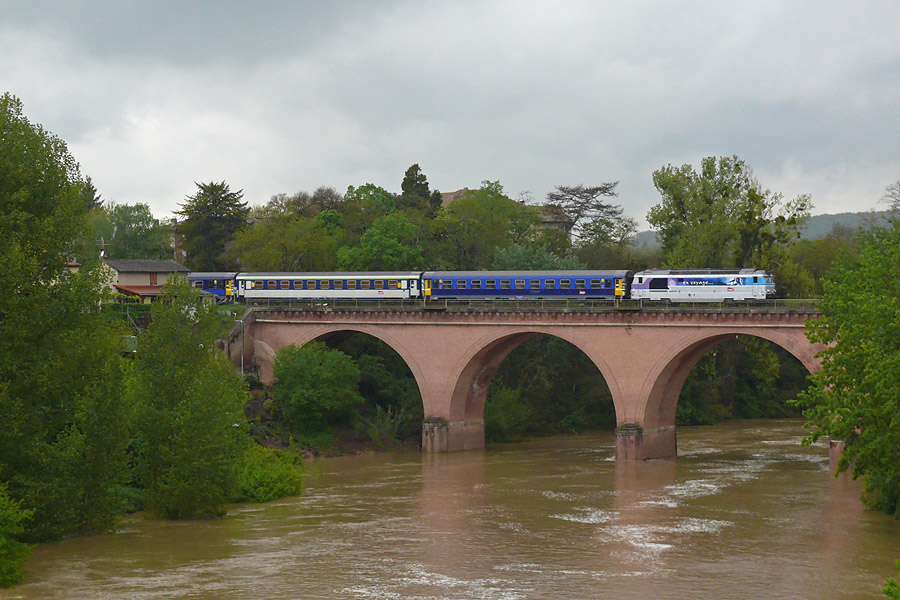 Le TER 870006 vient de quitter la gare de St Sulpice sur Tarn, et se dirige vers Rodez. Il est vue ici franchissant l'Agout en sortie de la gare.