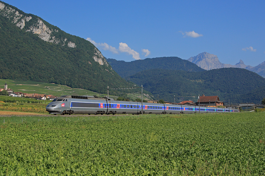 Le TGV Lyria 118 assure le TGV 9272 reliant Brig dans le canton du Valais à Paris. Ce dernier vient tout juste de quitter la gare d'Aigle, et passe devant le petit village d'Yvorne dont on aperçoit le clocher.