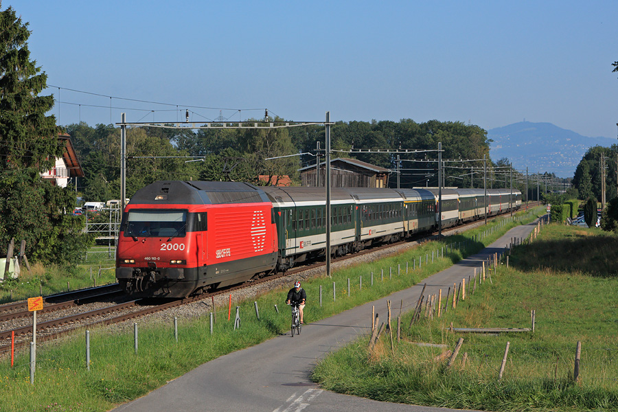La Re 460 110-0 est en charge de l'IR 1419 reliant Gen&egrave;ve &agrave; Brig. Elle est vue d&eacute;passant un cycliste du c&ocirc;t&eacute; de Versvey dans le canton de Vaud.
