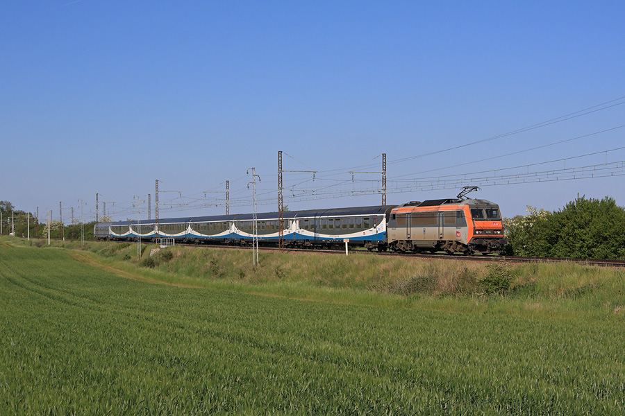 L'Interloire 860013 reliant Orléans à Nantes est vu du côté de Mer sur la double voie entre Orléans et Tours. Il est assuré par la BB 26016 remorquant une rame presque complète de voiture Interloire.