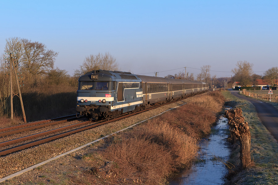 Longeant les marais du Marquenterre, du côté de Larronville, la BB 67533 fonce vers Amiens avec son InterCités à destination de Paris-Nord. À noter, les trois saules têtards typiques du Parc du Marquenterre.