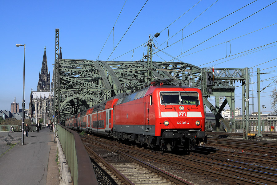 Normalement, les locos BR 120 sont engag&eacute;es avec des trains Intercity. Mais quelques unes d'entre elles ont &eacute;t&eacute; adapt&eacute;es pour les trains r&eacute;gionaux, et renum&eacute;rot&eacute;es. La 120 208 (ex 120 138) vient de franchir la Hohenzollernbr&uuml;cke devant la cath&eacute;drale de Cologne qui se cache en arri&egrave;re-plan.
