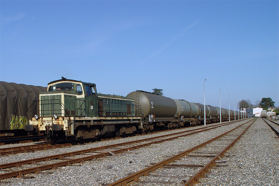 Le train 84426 Mont de Marsan - Hourcade pr&ecirc;t au d&eacute;part de la capitale des Landes. C'est un train de citernes d'essence de l'arm&eacute;e de l'air, qui permet l'approvisionnement en k&eacute;ros&egrave;ne les avions de la BA 118. En t&ecirc;te du train, le BB 64028, ancienne locomotive SNCF qui appartient &agrave; VFLI. A Morcenx, ce train sera repris par une locomotive de la SNCF.