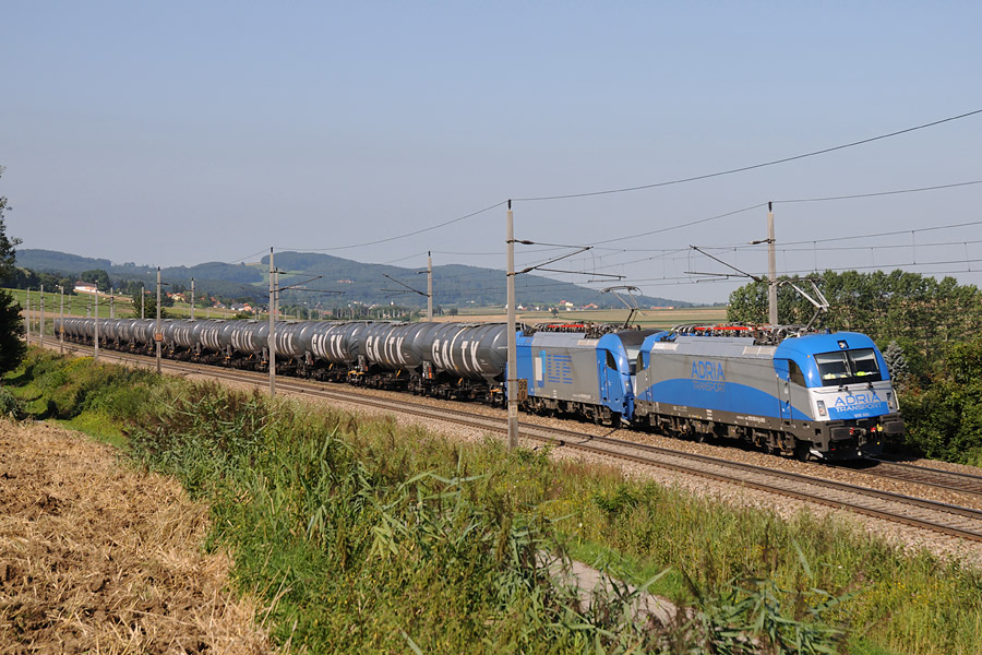 Train Adria Transport avec son UM de Taurus 1216 aux marquages ADRIA TRANSPORT et LTE. Ce train entier de produit pétrolier arrive de Koper et est destiné à la raffinerie OMV (Österreichischen Mineralölverwaltung) de Schwechat, près de Wien