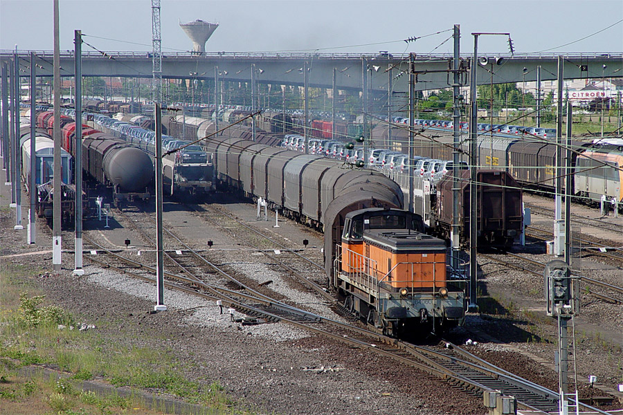 Le BB 64060 manoeuvre une rame de wagons plat bach&eacute;s, cot&eacute; sud du faisceau d&eacute;part du triage de Woippy.