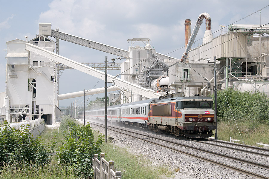 L'EuroCity 67 Paris-Est - M&uuml;nchen Hbf, &agrave; Sorcy St Martin, tract&eacute; par la BB 15003. De part et d'autre de la voie s'&eacute;tend l'usine des fours &agrave; Chaux de Sorcy.