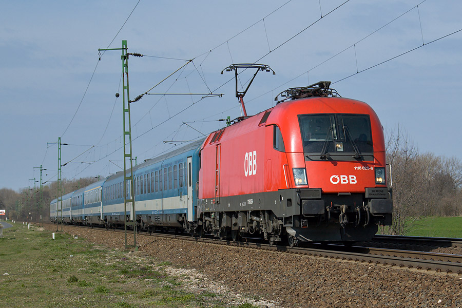 Passage &agrave; Szony (commune de Komarom) de la 1116 025-6 des &Ouml;BB sur l'EN 467 Z&uuml;rich Hb - Budapest-Keleti-pu. Seules les deux voitures de t&ecirc;te sont en provenance de Z&uuml;rich, les autres voitures ont &eacute;t&eacute; ajout&eacute;es lors du rebroussement &agrave; Wien Westbf. &Agrave; noter en quatri&egrave;me position, la voiture restaurant.