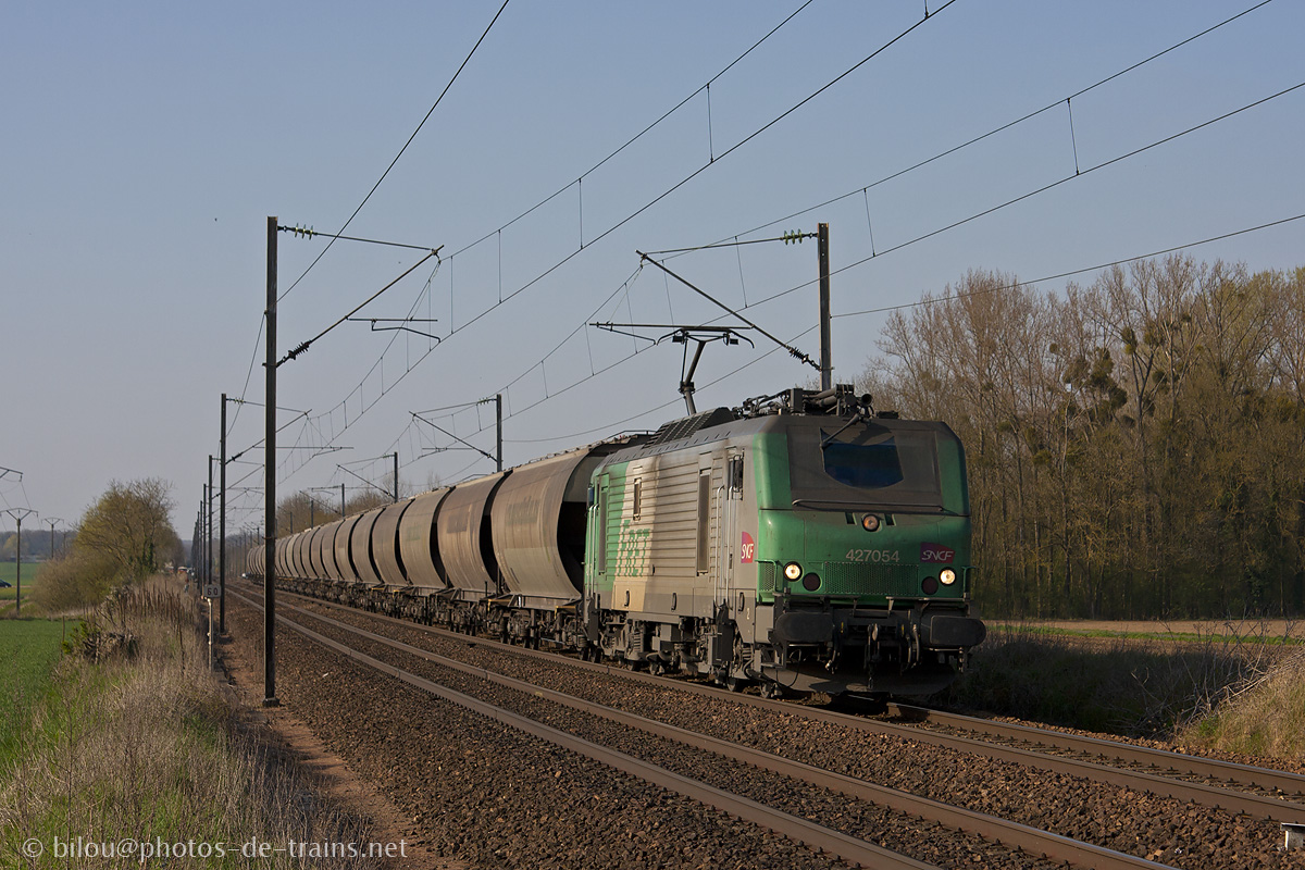 La 27054 accompagne sa rame de céréaliers reliant Lille à Bobigny, le tout vu peu avant Liancourt-Rantigny.